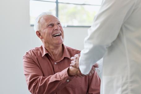 Arzt schüttelt Patient die Hand